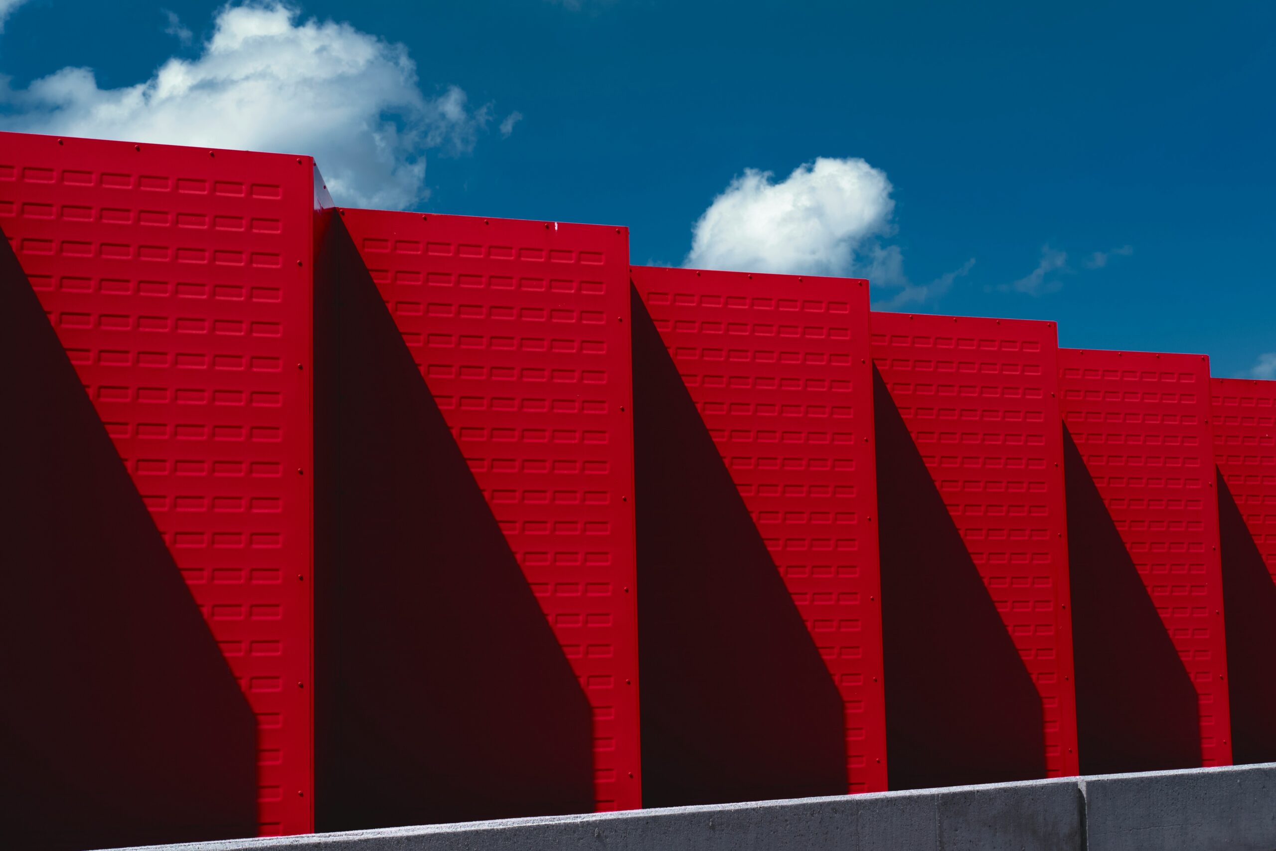 a row of red brick wall with a blue sky in the background etfe film